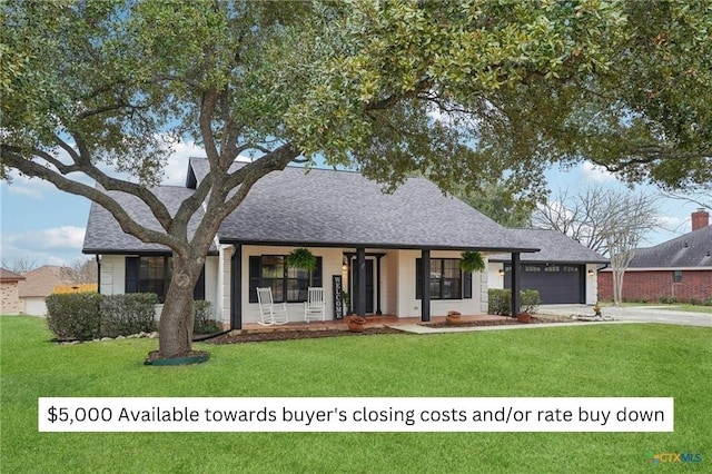 view of front of house with a front yard, a porch, a garage, and driveway