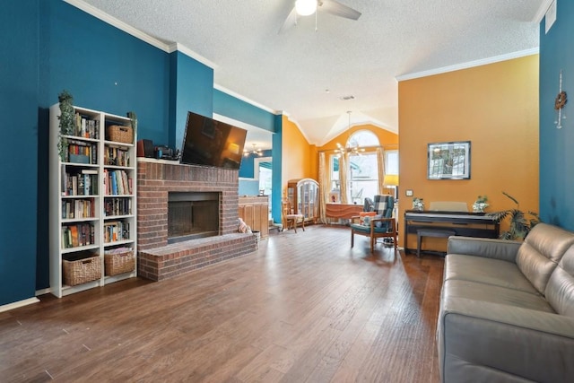 living room featuring a brick fireplace, wood-type flooring, ornamental molding, and a textured ceiling