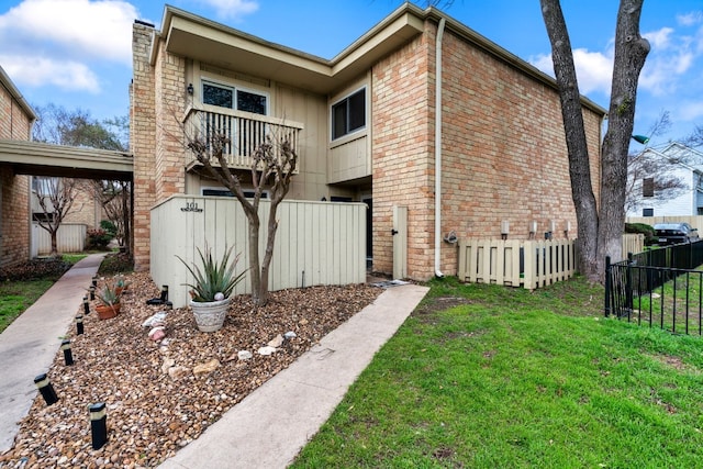 view of side of home with a balcony and a lawn