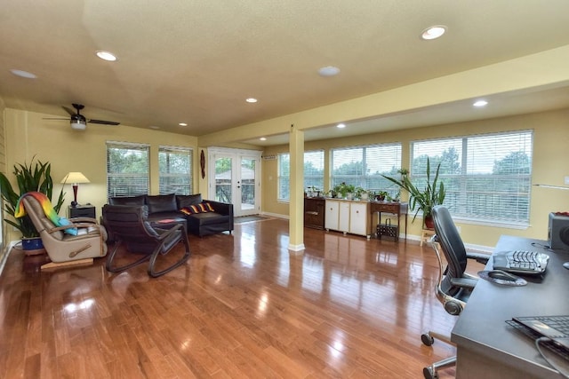 interior space with a wealth of natural light, hardwood / wood-style floors, ceiling fan, and french doors