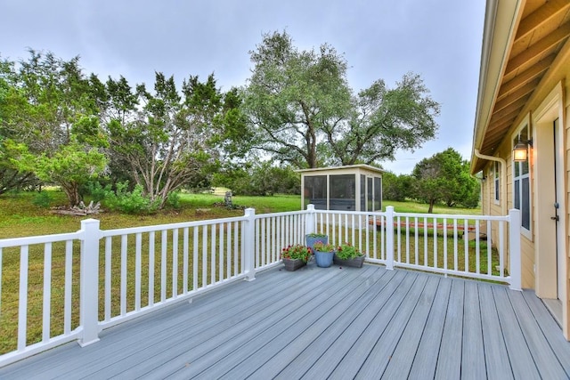 wooden deck featuring a lawn and a sunroom