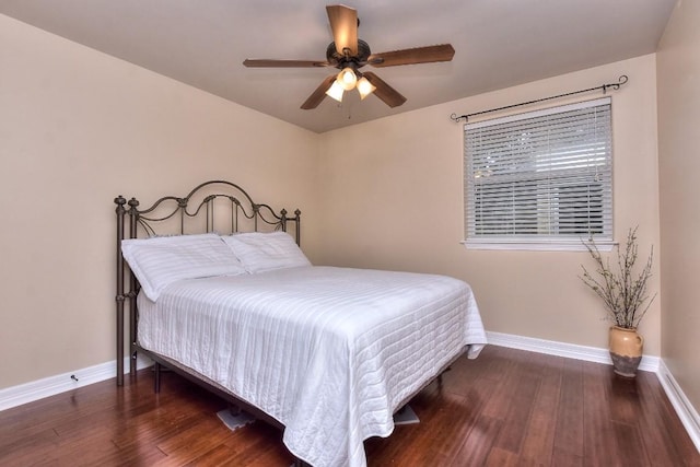 bedroom with dark hardwood / wood-style flooring and ceiling fan