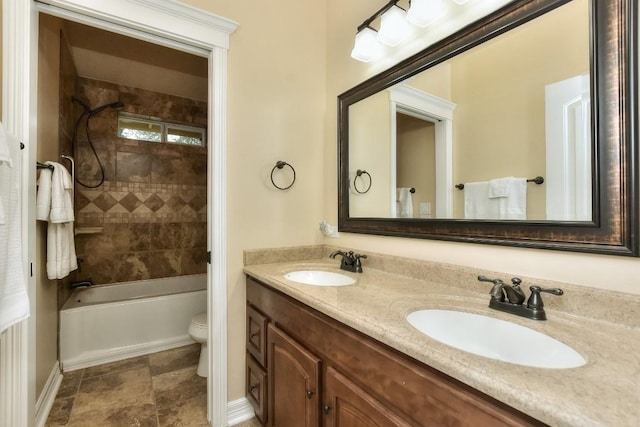 full bathroom featuring tiled shower / bath combo, vanity, and toilet