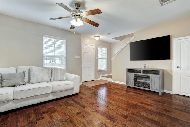 living room featuring baseboards, ceiling fan, wood finished floors, and visible vents