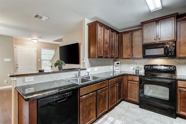kitchen featuring decorative backsplash, visible vents, a sink, black appliances, and a peninsula