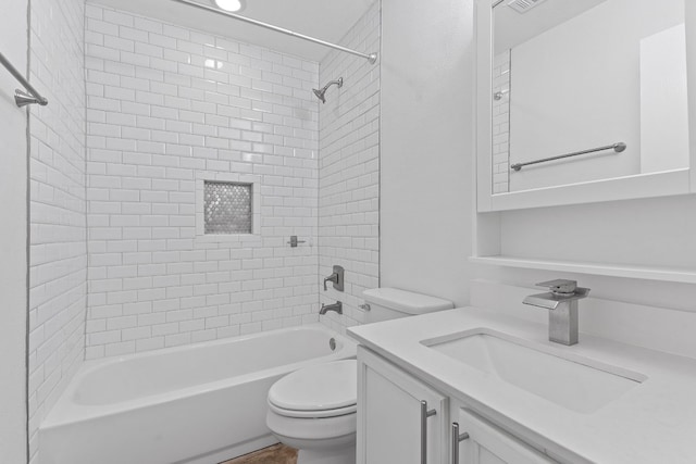 full bathroom with vanity, tiled shower / bath combo, and toilet