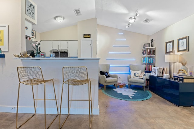 kitchen featuring lofted ceiling, kitchen peninsula, and white cabinets