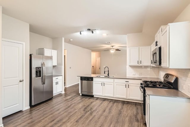 10801 Dimitrios Dr, Austin, TX 78747 - kitchen with stainless steel appliances, a peninsula, decorative backsplash, wood finished floors, and ceiling fan