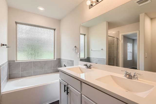 10801 Dimitrios Dr, Austin, TX 78747 - bathroom with a bath, double vanity, healthy amount of natural light, a shower stall, and recessed lighting