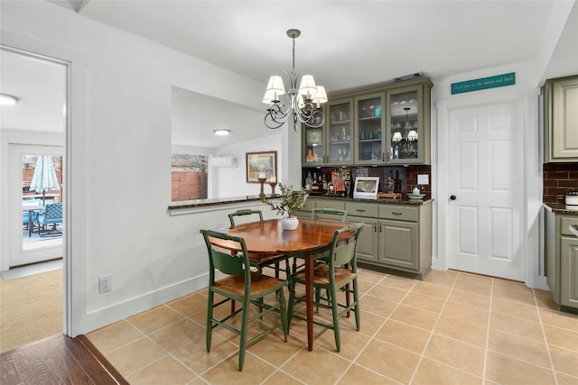 dining space with light tile patterned floors, baseboards, and an inviting chandelier