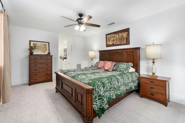 bedroom featuring ceiling fan, visible vents, ensuite bathroom, and light carpet