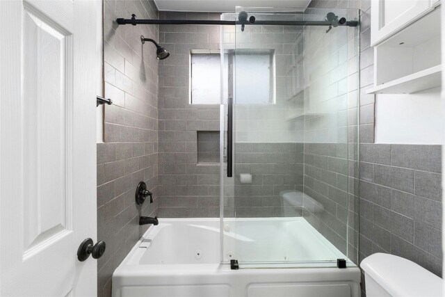 bathroom with enclosed tub / shower combo and toilet