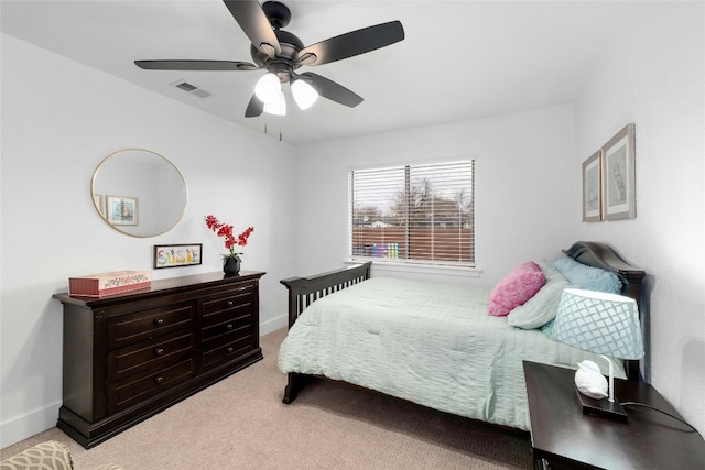 bedroom featuring a ceiling fan, light colored carpet, visible vents, and baseboards