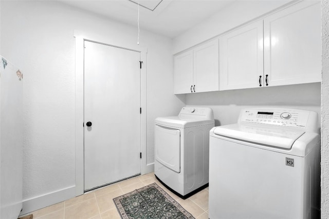 washroom featuring baseboards, attic access, light tile patterned floors, cabinet space, and separate washer and dryer