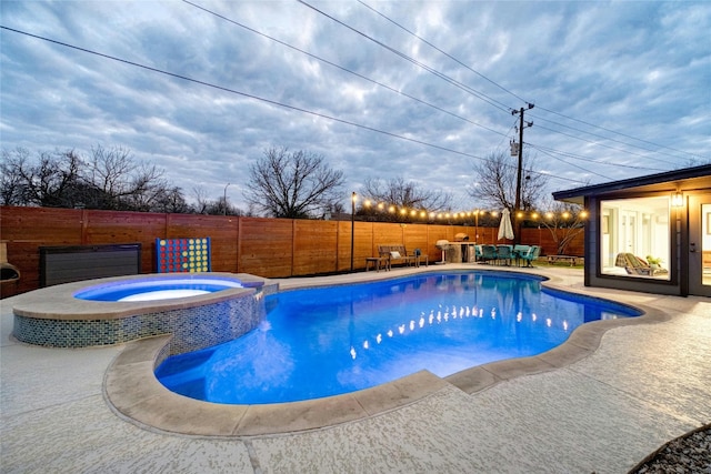 view of pool with a patio area, a pool with connected hot tub, and a fenced backyard