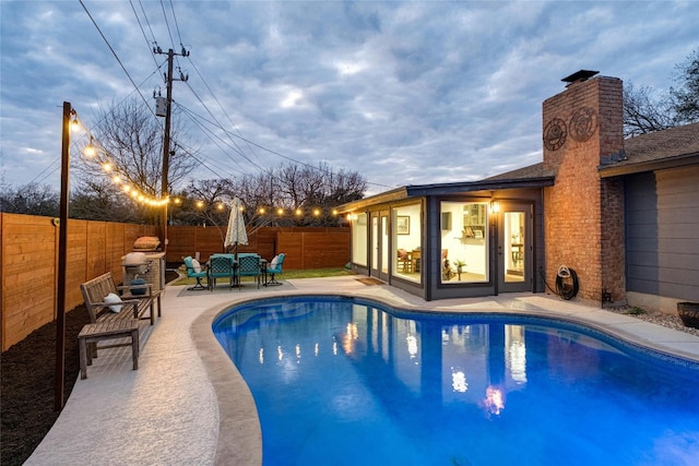 view of swimming pool featuring a fenced backyard, a fenced in pool, and a patio