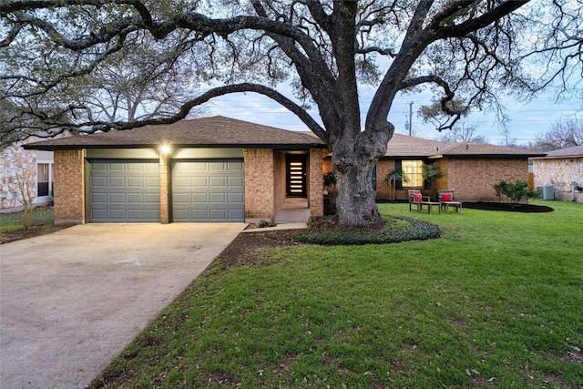 single story home with brick siding, a front lawn, cooling unit, driveway, and an attached garage