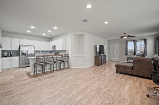 living room featuring ceiling fan and light hardwood / wood-style flooring