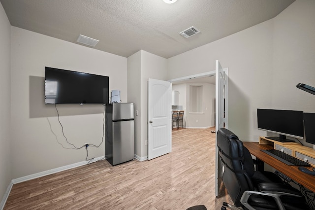 office area featuring a textured ceiling and light wood-type flooring