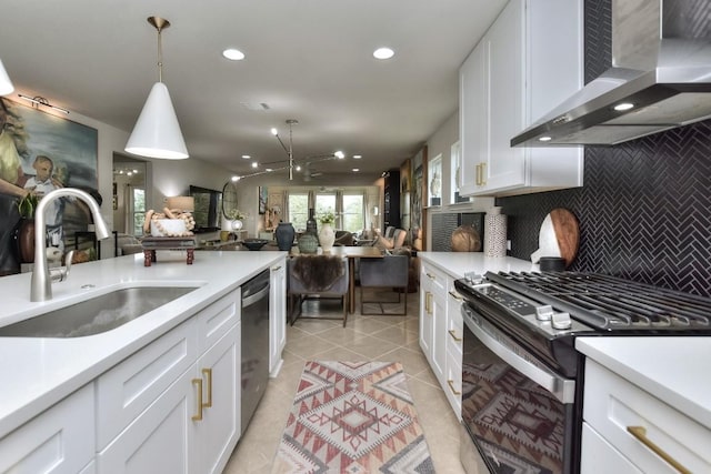 kitchen featuring wall chimney range hood, sink, dishwasher, white cabinetry, and stainless steel range with gas cooktop