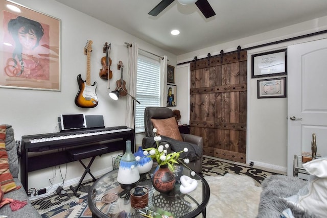 sitting room featuring a barn door and ceiling fan