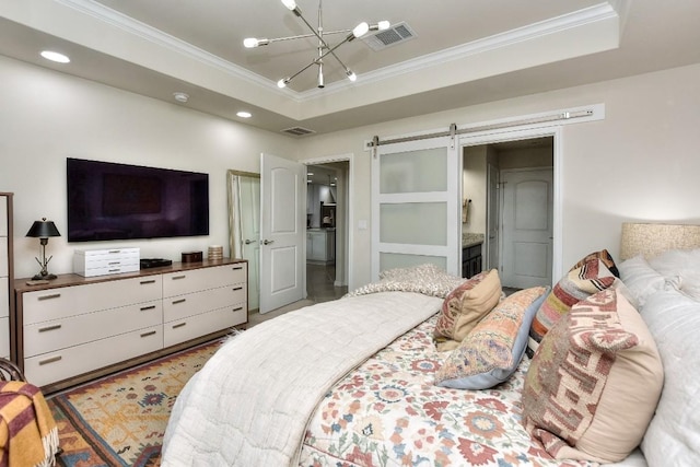 bedroom with crown molding, a barn door, an inviting chandelier, and a tray ceiling