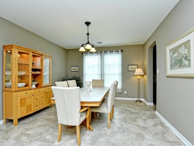 1533 Cresson Trl, Leander, TX 78641 - dining area with arched walkways, baseboards, and light tile patterned floors