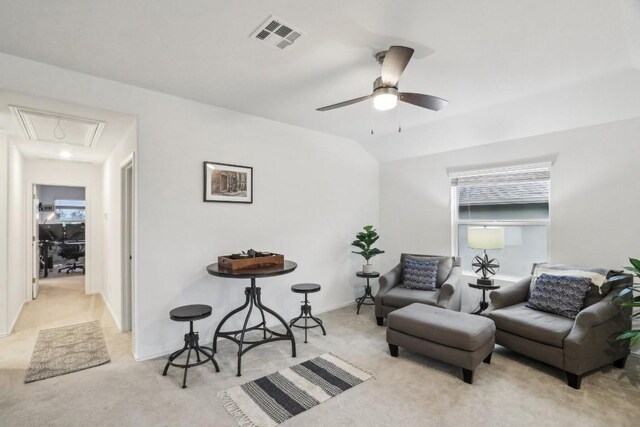 sitting room with ceiling fan, lofted ceiling, and light carpet