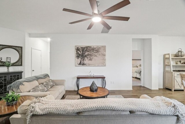 living room featuring light hardwood / wood-style flooring and ceiling fan