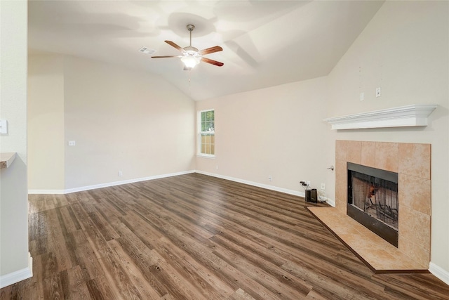 18825 Golden Eagle Way, Elgin, TX 78621 - unfurnished living room featuring wood finished floors, a ceiling fan, a tiled fireplace, and vaulted ceiling