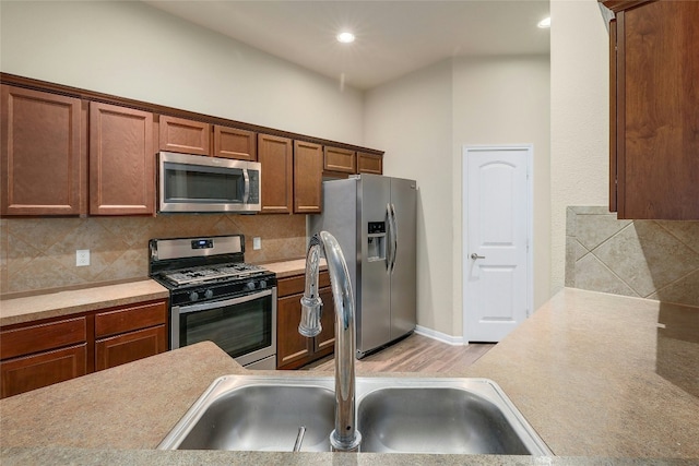 18825 Golden Eagle Way, Elgin, TX 78621 - kitchen featuring appliances with stainless steel finishes, tasteful backsplash, light countertops, recessed lighting, and brown cabinetry