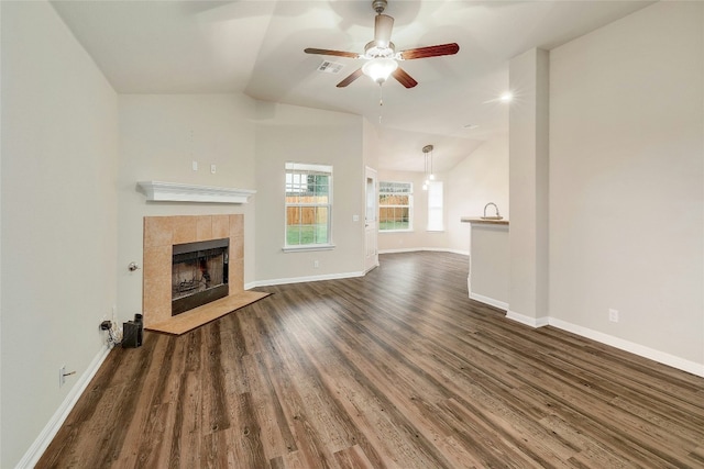 18825 Golden Eagle Way, Elgin, TX 78621 - unfurnished living room with dark wood-style floors, lofted ceiling, ceiling fan, and a tiled fireplace