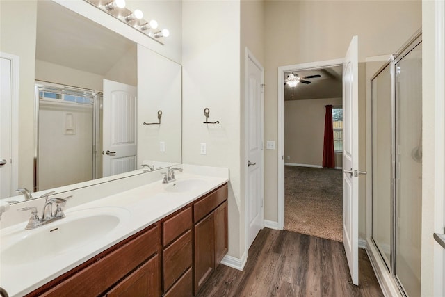 18825 Golden Eagle Way, Elgin, TX 78621 - full bathroom featuring a shower stall, wood finished floors, double vanity, and a ceiling fan