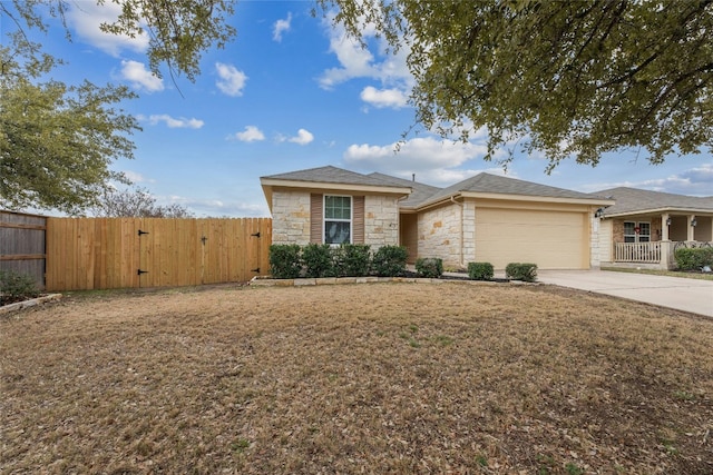 18825 Golden Eagle Way, Elgin, TX 78621 - view of front facade with stone siding, a gate, concrete driveway, and an attached garage