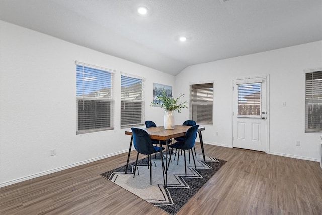 dining space with lofted ceiling, recessed lighting, wood finished floors, and baseboards