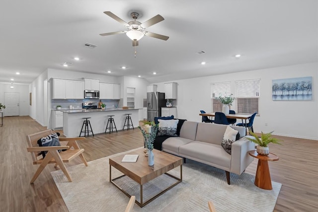 living room featuring recessed lighting, visible vents, and light wood finished floors