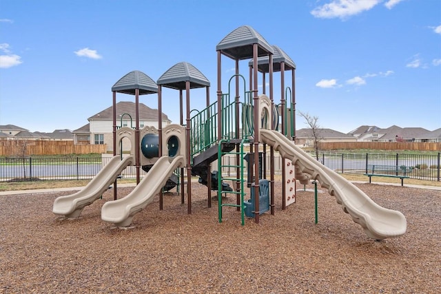 communal playground with a residential view and fence