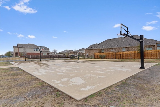 view of basketball court with community basketball court, a residential view, and fence