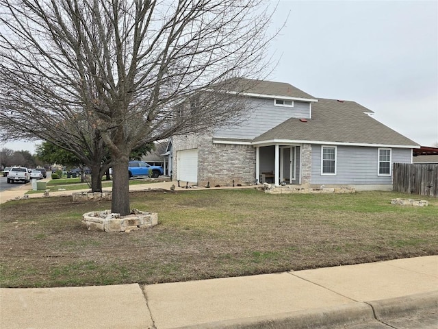 view of property featuring a garage and a front lawn