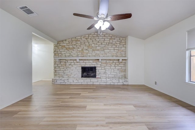 unfurnished living room featuring ceiling fan, lofted ceiling, a brick fireplace, and light hardwood / wood-style flooring