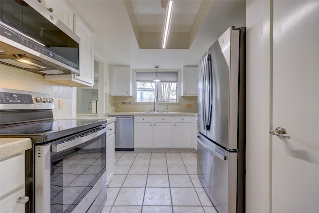 803 Castle Ridge Rd, Austin, TX 78746 - kitchen featuring stainless steel appliances, light countertops, white cabinets, light tile patterned flooring, and pendant lighting
