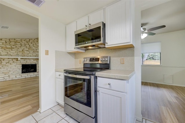 kitchen with ceiling fan, appliances with stainless steel finishes, tasteful backsplash, light hardwood / wood-style floors, and white cabinets