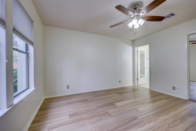 empty room with ceiling fan and light hardwood / wood-style floors