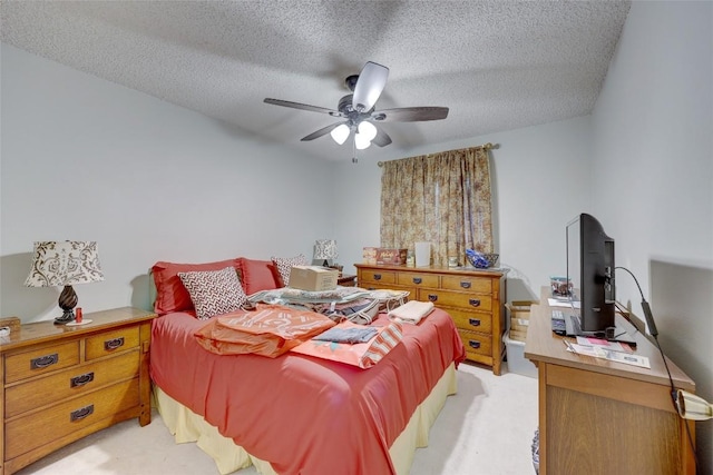 bedroom featuring ceiling fan, light colored carpet, and a textured ceiling