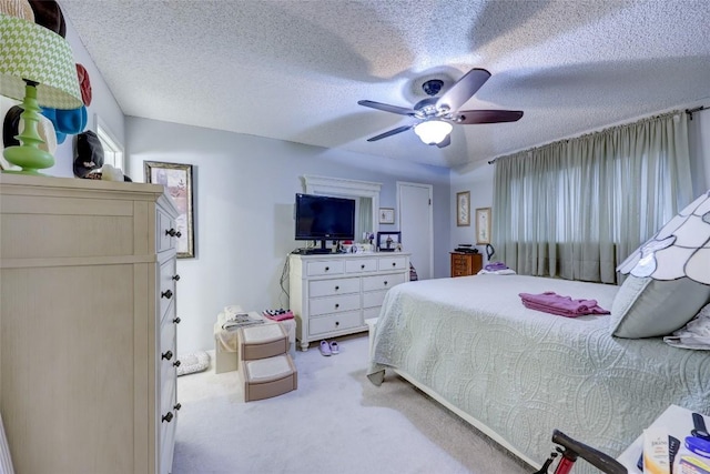 bedroom featuring ceiling fan, light carpet, and a textured ceiling