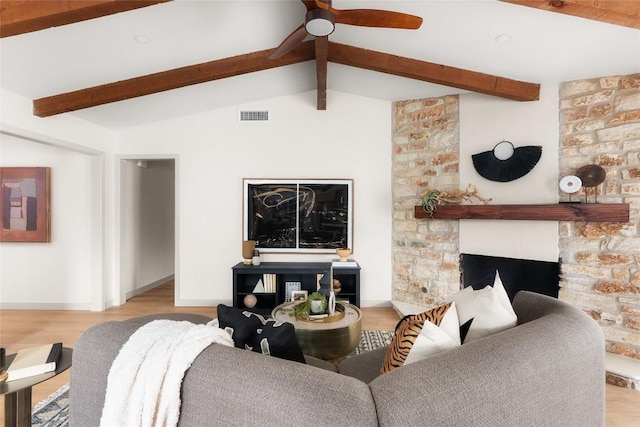 living room featuring ceiling fan, vaulted ceiling with beams, a fireplace, and light hardwood / wood-style flooring