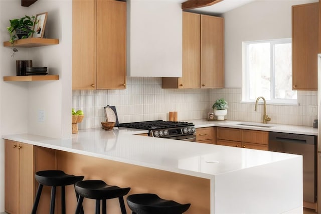 kitchen with stainless steel range with gas cooktop, sink, dishwashing machine, decorative backsplash, and kitchen peninsula