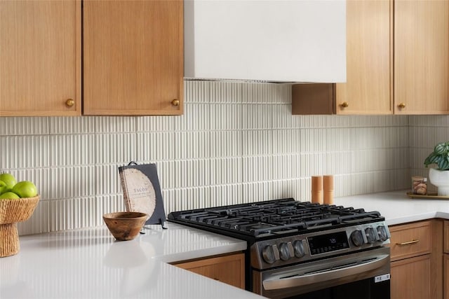 kitchen featuring tasteful backsplash, gas stove, and exhaust hood