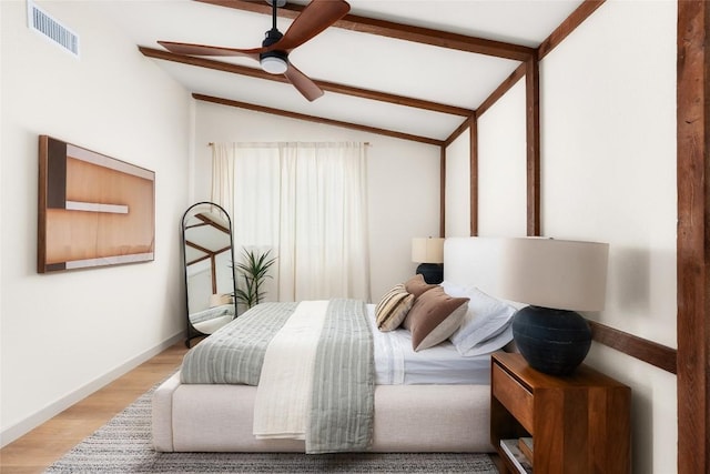 bedroom with lofted ceiling with beams, ceiling fan, and light hardwood / wood-style floors