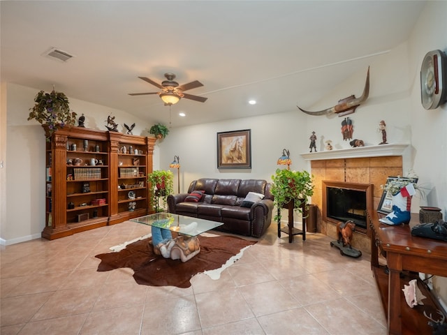 living room with light tile patterned floors, a fireplace, and ceiling fan